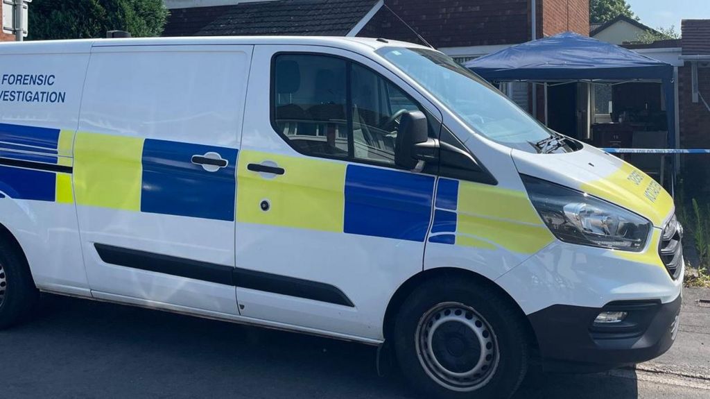 A police van marked 'forensic investigation' parked outside the house