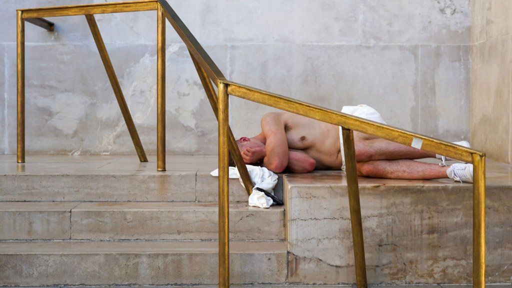 A shirtless Rangers fan lies down on some steps