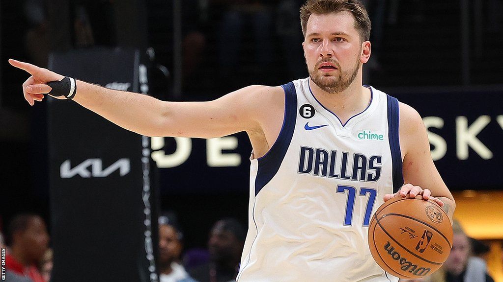 Luka Doncic points while holding the ball when playing for the Dallas Mavericks