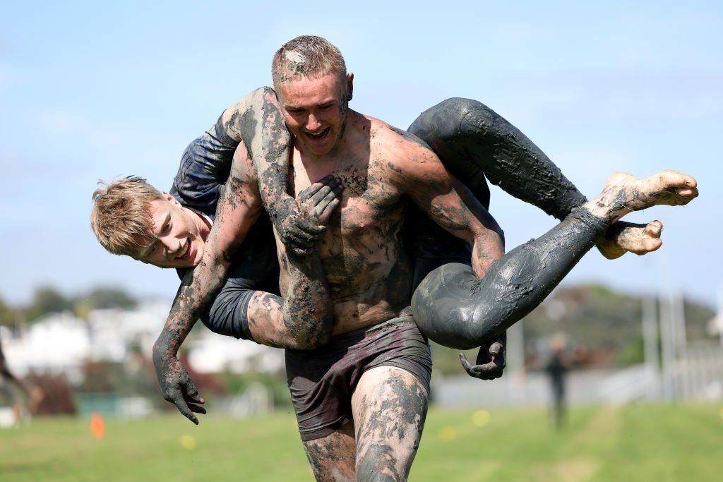 Tristyn Cook of the Blues holds Cam Christie during an Auckland Blues mud run training session at Devonport Naval Base in Auckland, New Zealand