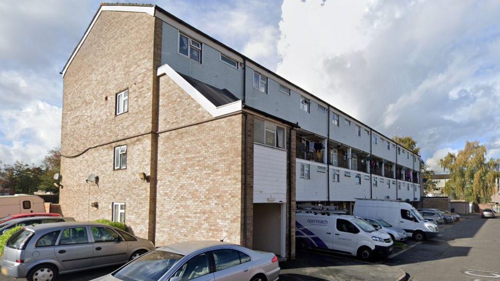 The outside of homes in Cobbetts Cl, Woking, showing low rise block of flats with white cladding on the walls