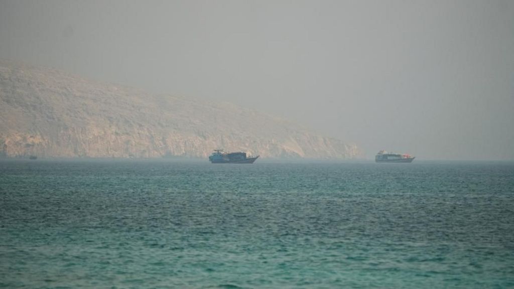 Two vessels are seen in the Strait of Hormuz, surrounded by rocky mountains, from Musandam, Oman