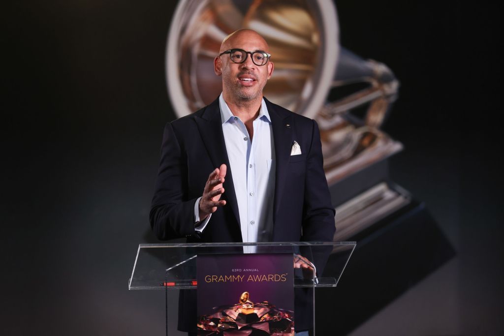Harvey Mason, Jr standing at a podium in a jacket and shirt