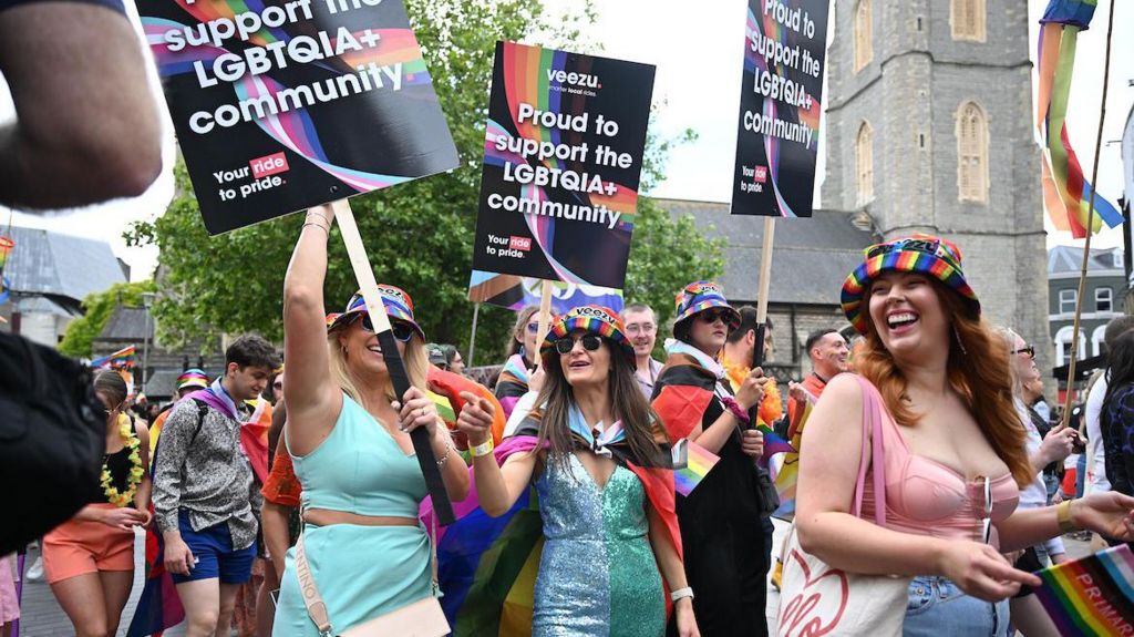 Women hold placards during Pride Cymru parade