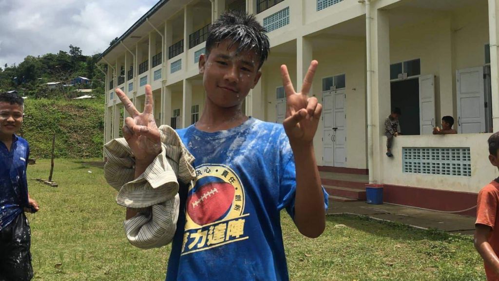 Lalruatmawia, 15, is seen in a blue T-shirt in front of a building