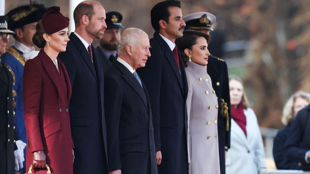 Kate, William, the King, the Emir of Qatar and his wife stand in a line looking out over the Mall