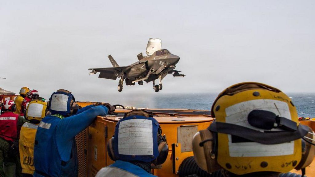 US service members aboard the USS Boxer amphibious assault ship watch a US fighter jet in flight. File photo