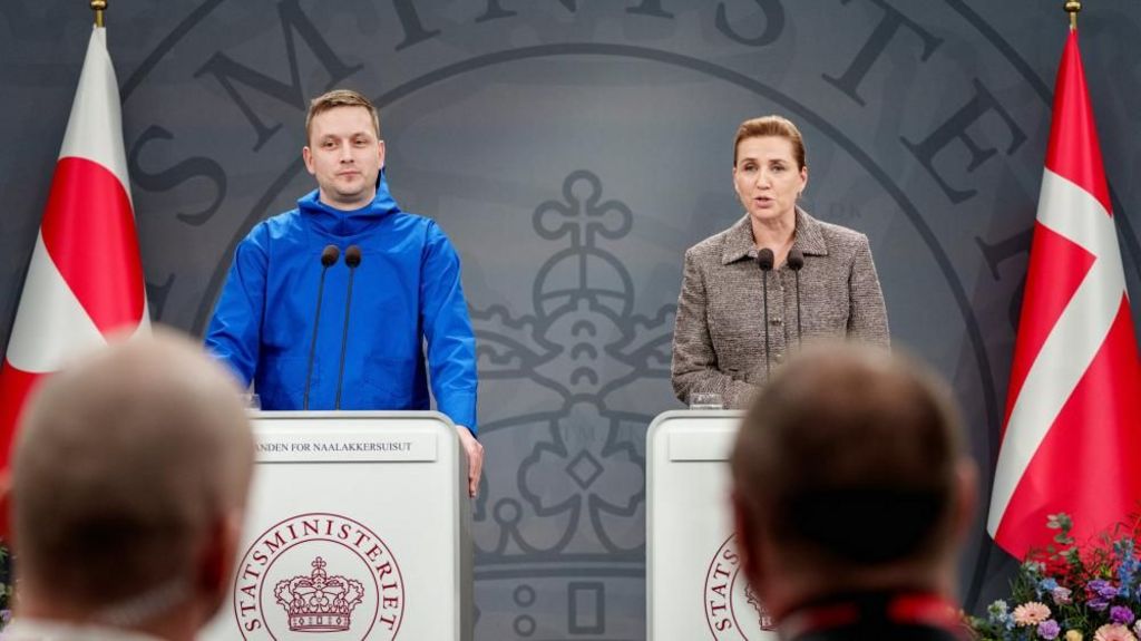 Greenland's Prime Minister, Jens-Frederik Nielsen and Denmark's Prime Minister Mette Frederiksen standing side-by-side at two separate lecterns with microphones during a press conference in Copenhagen, Denmark.