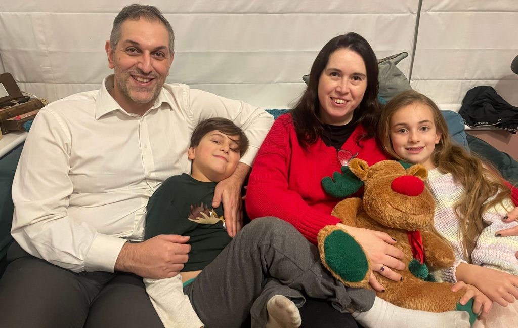 Omid, Deborah and their children on the sofa with a Rudolph cuddly toy