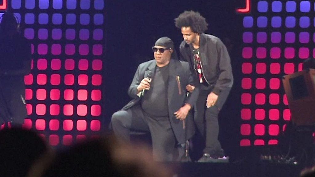 Stevie Wonder kneeling