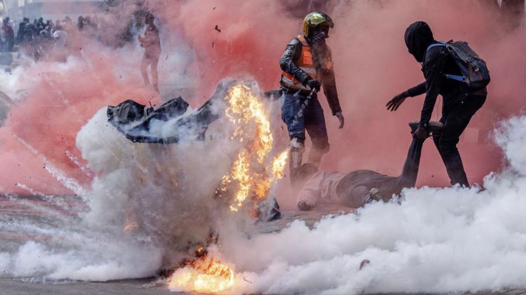 A tear gas canister explodes as protesters try to help injured people outside the Kenya Parliament during a nationwide strike to protest against tax hikes and the Finance Bill 2024 in downtown Nairobi, on June 25, 2024