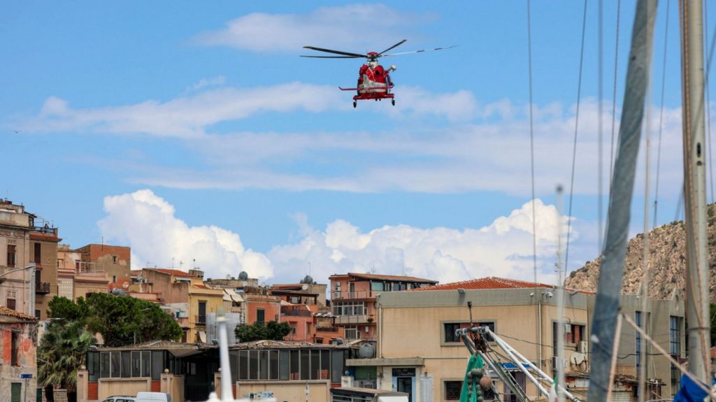 A helicopter arrives to reinforce the rescue operation for the missing yacht passengers, in Porticello, Sicily Island