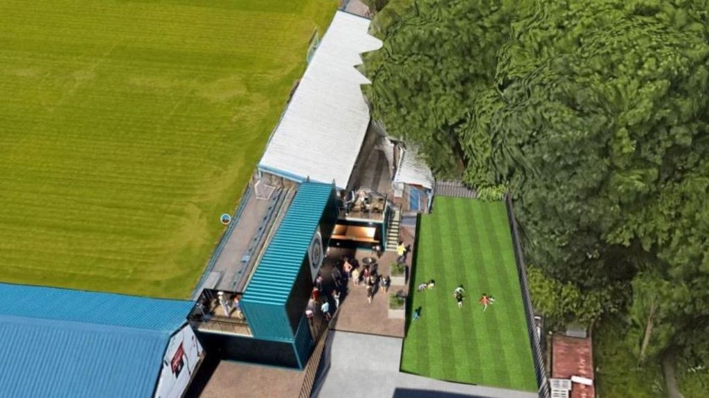 Drone CGI shot of new fan zone at Stalybridge Celtic showing the pitch on the right and fans milling round the zone at outdoor tables and playing football on artificial turf.