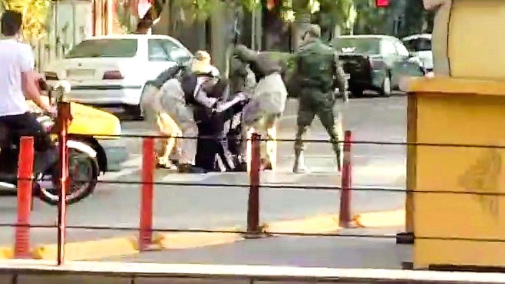 A woman being detained by female special forces in the middle of a road in the Iranian city of Tabriz on 14 October 2022