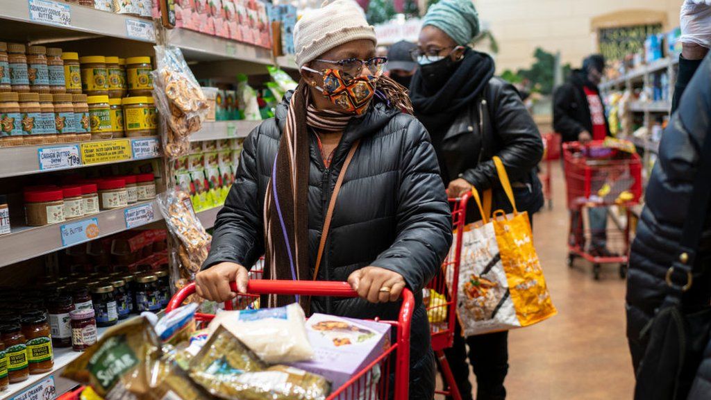Woman shopping in US supermarket wearing a face mask.