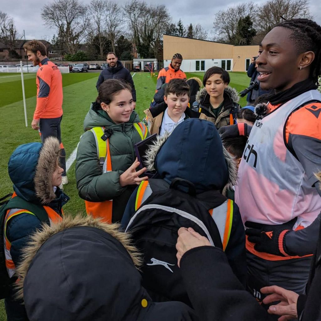 England player Eberechi Eze stands talking to pupils at his former school - Fossdene Primary School - on the school field