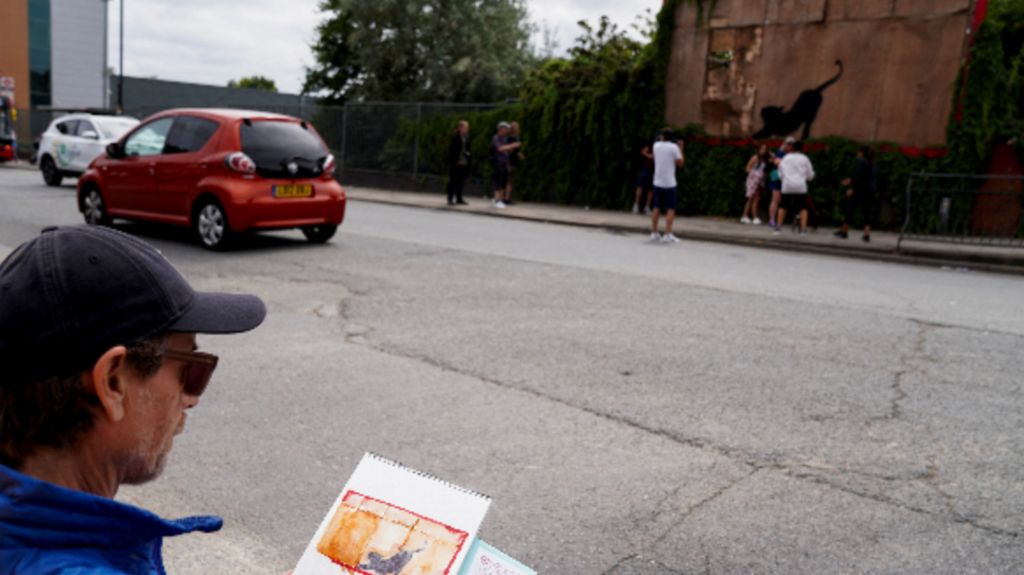 A photo of a man painting the painting