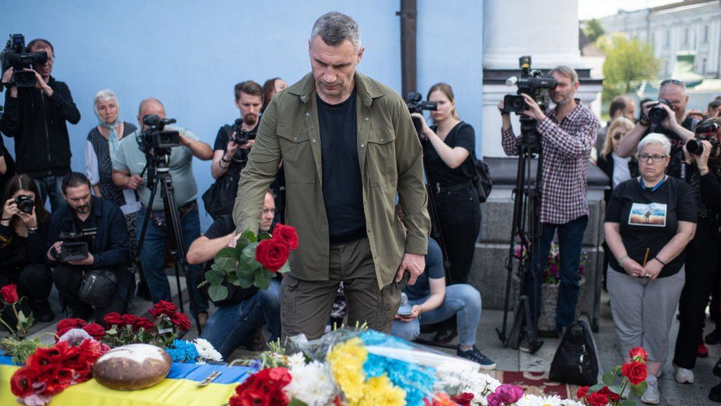 Kyiv's Mayor Vitali Klischko lays flowers on Roman Ratushny's coffin during a memorial service in Kyiv