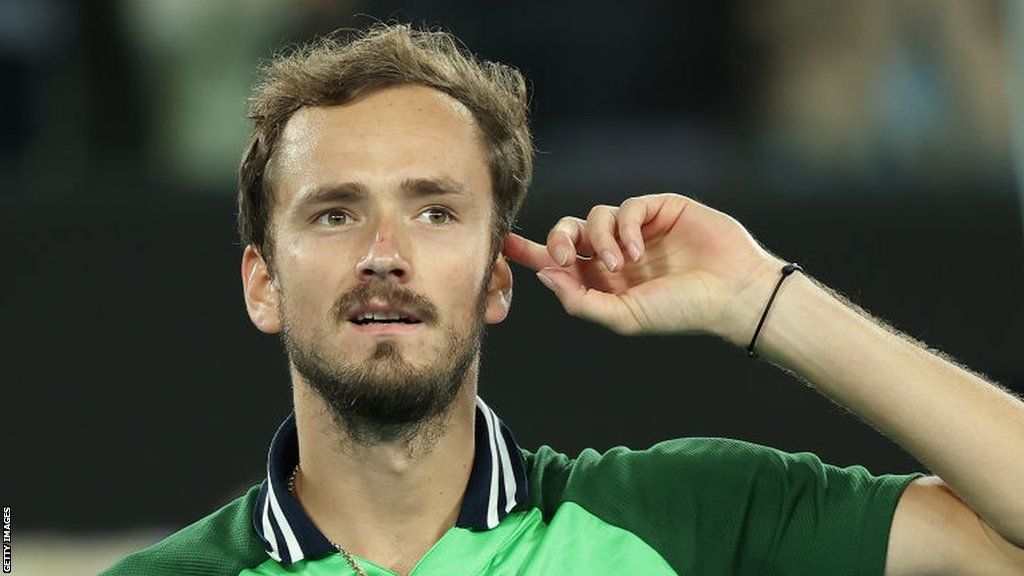 Daniil Medvedev points to his head after beating