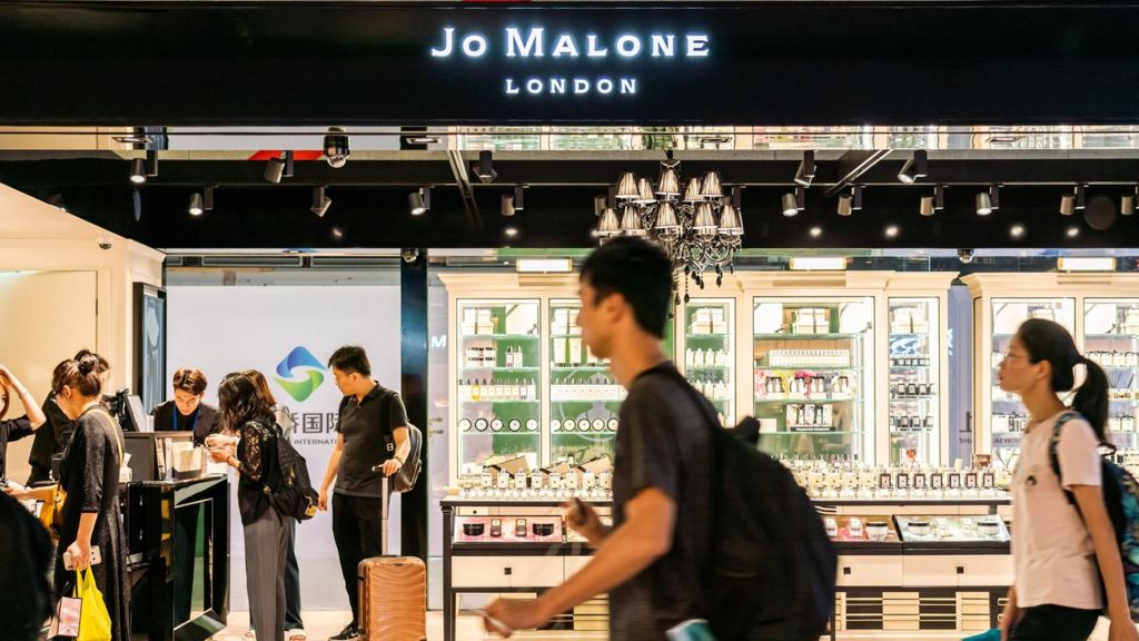 A Jo Malone shop with people walking past it.