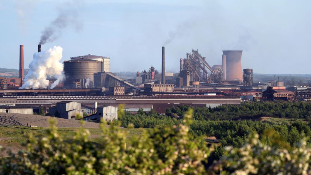 A landscape view of the steelworks at Scunthorpe, with several chimneys ejecting smoke.