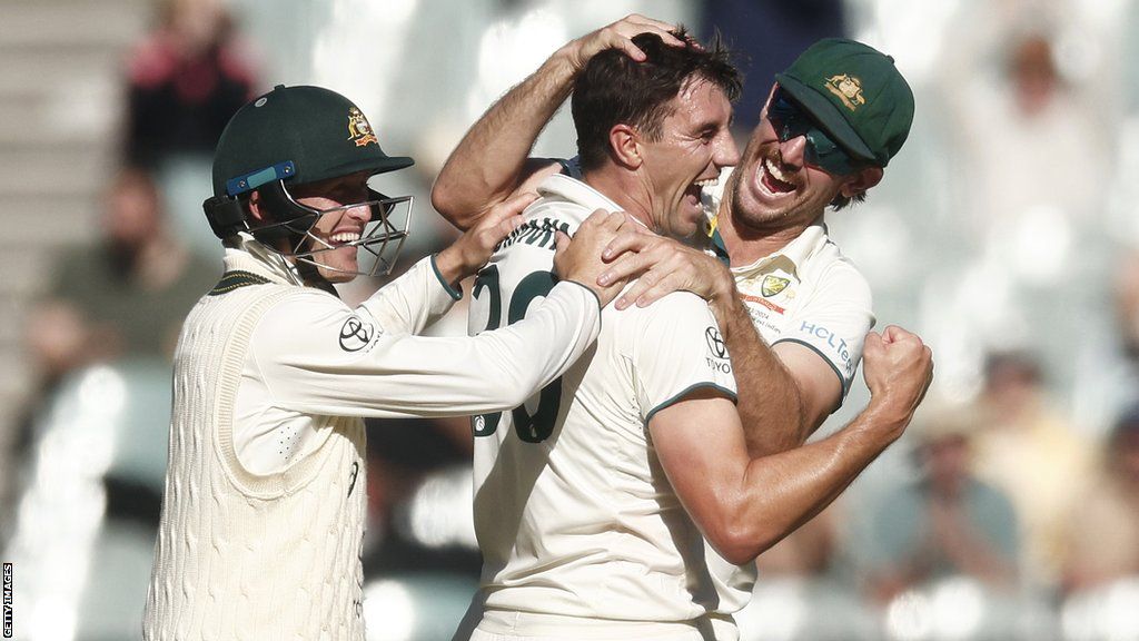 Pat Cummins (middle) celebrates a wicket with Marnus Labuschagne (left) and Mitchell Starc (right)