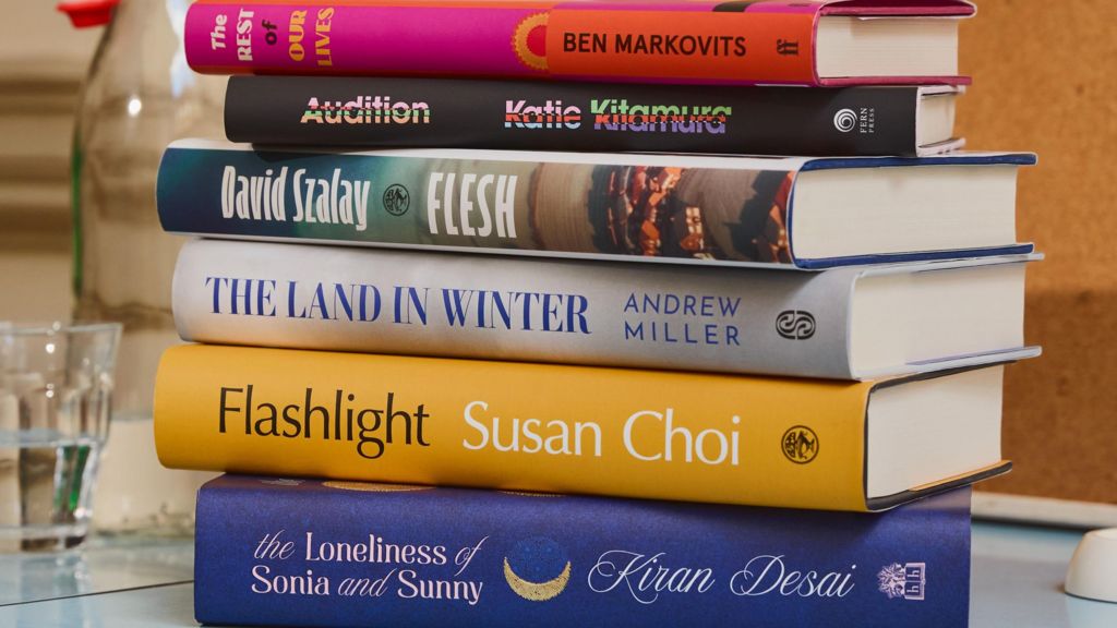 A stack of the six shortlisted books on a desk