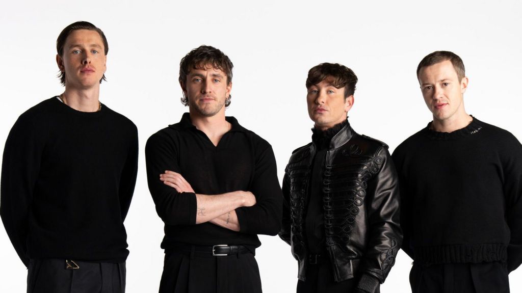 (Left to right) Actor Harris Dickinson as John Lennon, Paul Mescal as Paul McCartney, Barry Keoghan as Ringo Starr, and Joseph Quinn as George Harrison. They are all wearing black tops and black trousers.