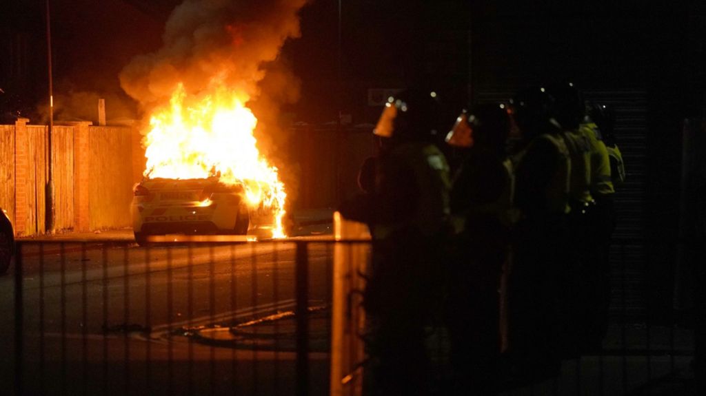 A car on fire during disorder that broke out across England