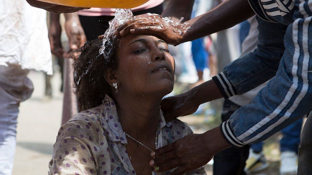 Men wash the face of a woman after police used teargas during the Oromo new year holiday