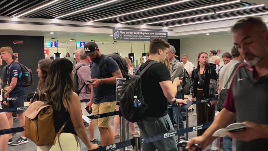 People move through the queue for the Entry Exit System process at Fuimicino Airport in Rome, Italy.