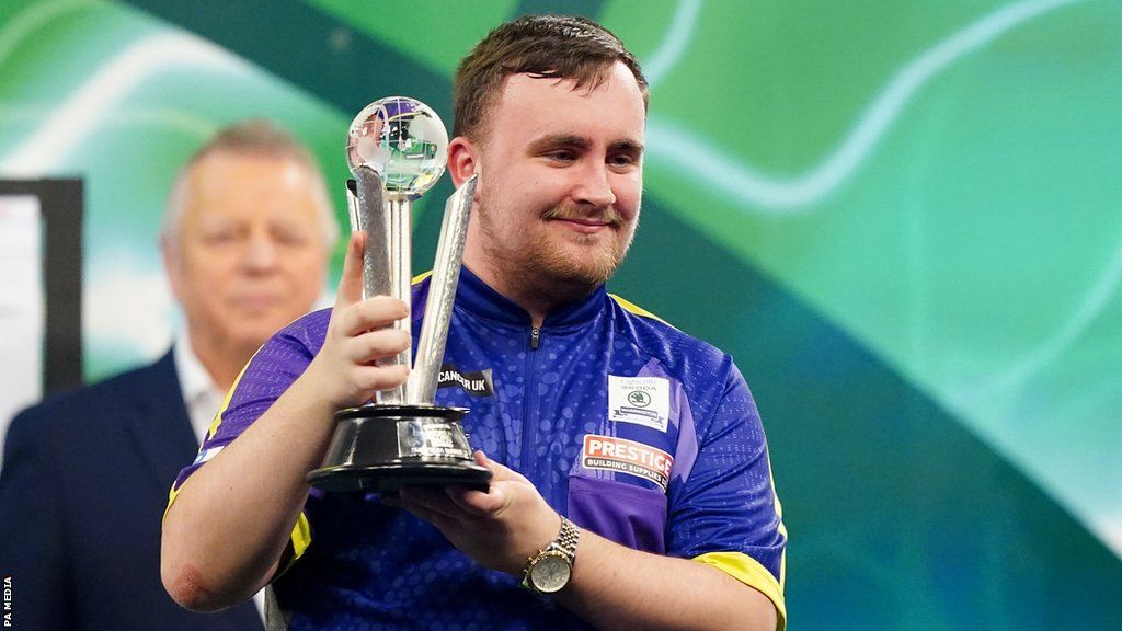 Luke Littler holds up the runners-up trophy after defeat by Luke Humphries in the 2024 PDC World Darts Championship final