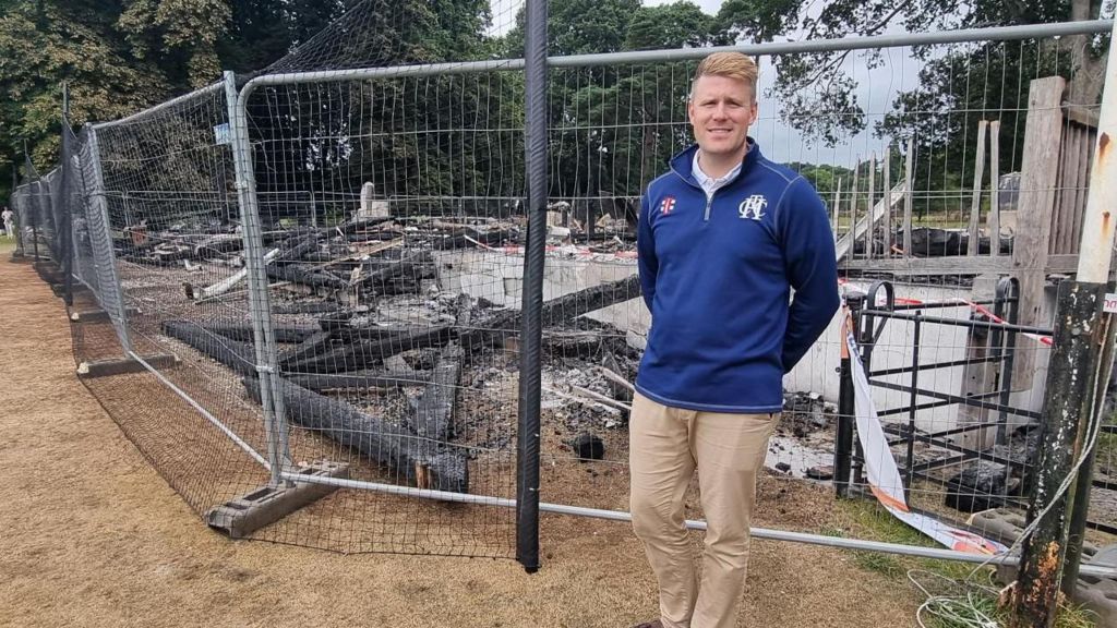 Pete Randerson former club captain at Heathcoat Cricket Club stands in front of the wreckage of the clubhouse after it was destroyed by fire. 