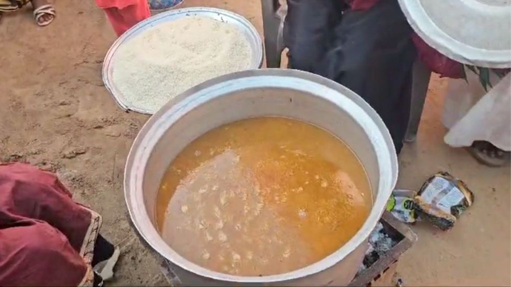 Two large pots of food - one appears to contain rice while the other contains a yellowy-brown stew.