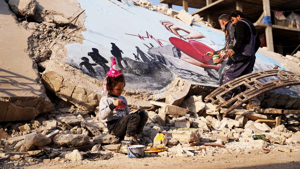 Сирийские художники-граффити изображают борьбу землетрясений на обломках рухнувшего здания в Джиндиресе, район Африн, Сирия, 22 февраля