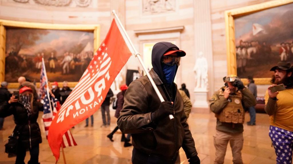 Rioter in the capitol rotunda with Trump flag