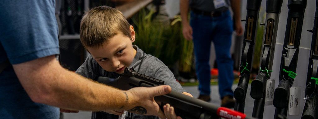 Мальчик держит огнестрельное оружие