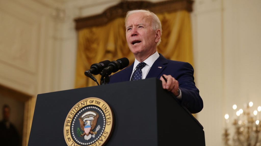 Joe Biden speaking at a presidential podium.