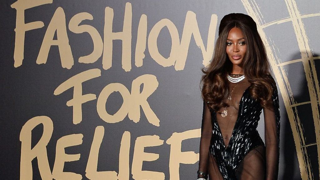 Naomi Campbell posing in front of a giant Fashion For Relief sign at the British Museum in 2019