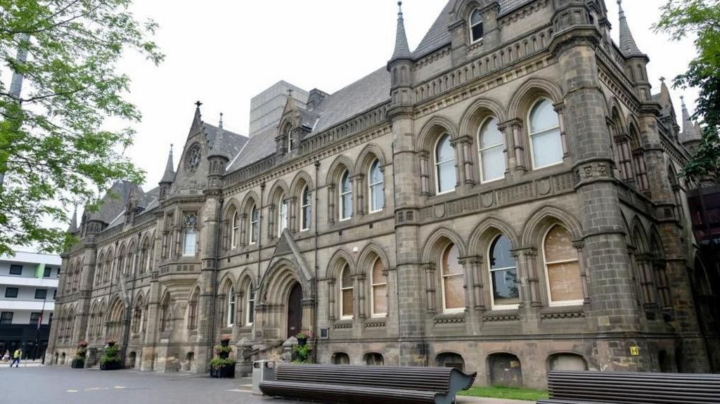  Middlesbrough Town Hall, a grand grey building with spires. There are benches outside.