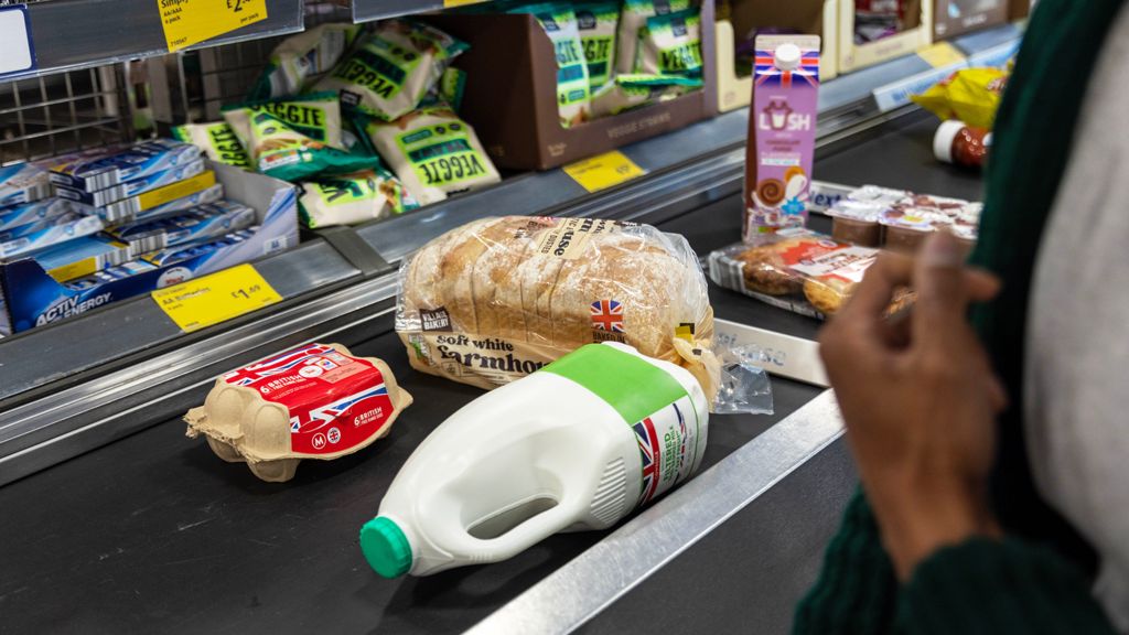 Eggs, bread, milk, and other food on a conveyor belt