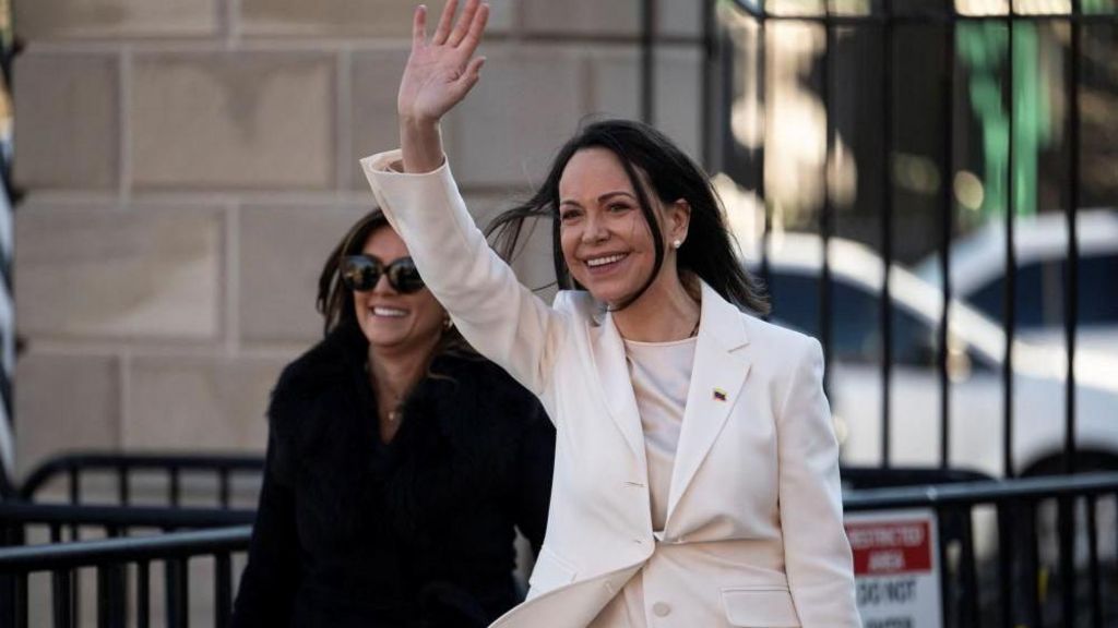 Machado wears a white suit and waves after leaving the White House