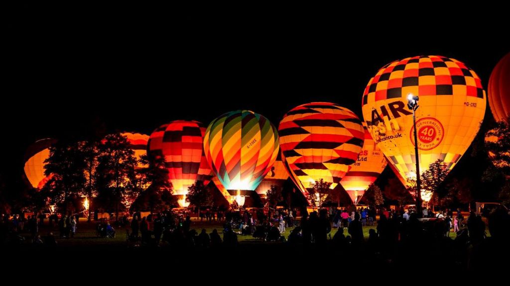 Hot air balloons lit up during a night glow at Longleat