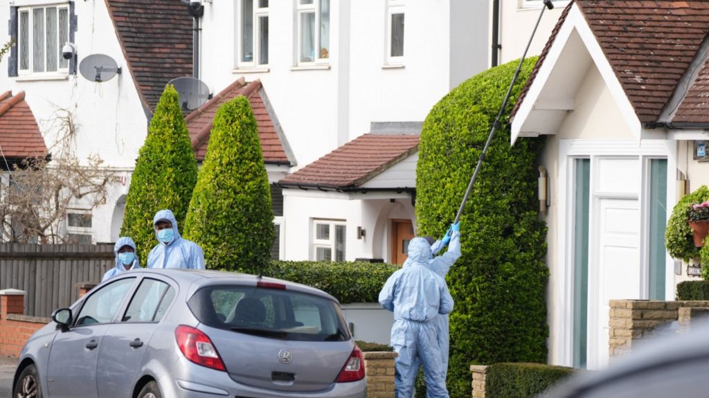 Police officers search on Brookside Road at the junction with Russell Gardens near to the scene in Highfield Road, Golders Green