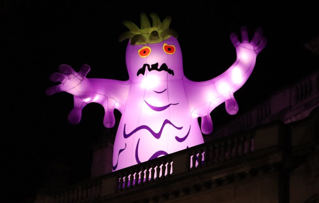 A purple monster at the top of a building