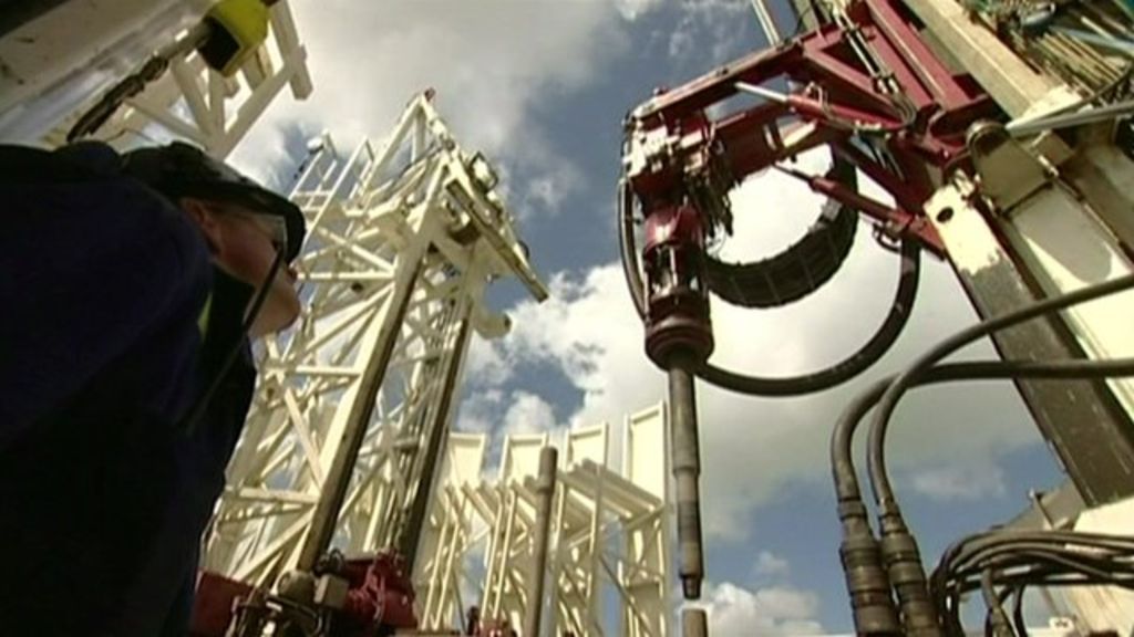 Man looking up at fracking equipment