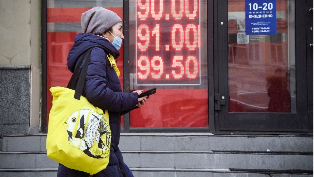 A woman walks by a currency exchange in Moscow