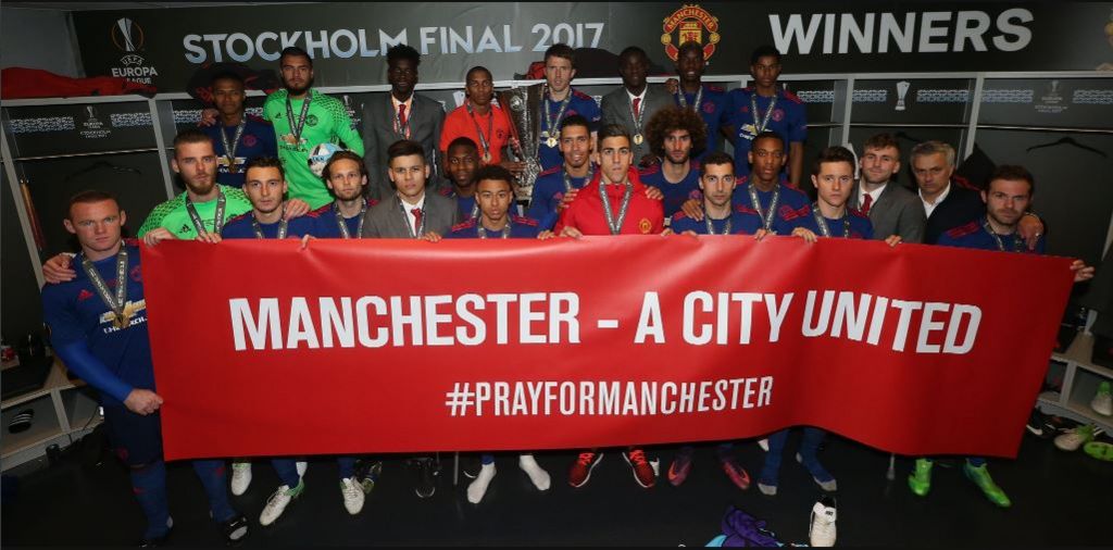 The Manchester United players pose with a banner for those who lost their lives in the Manchester attack