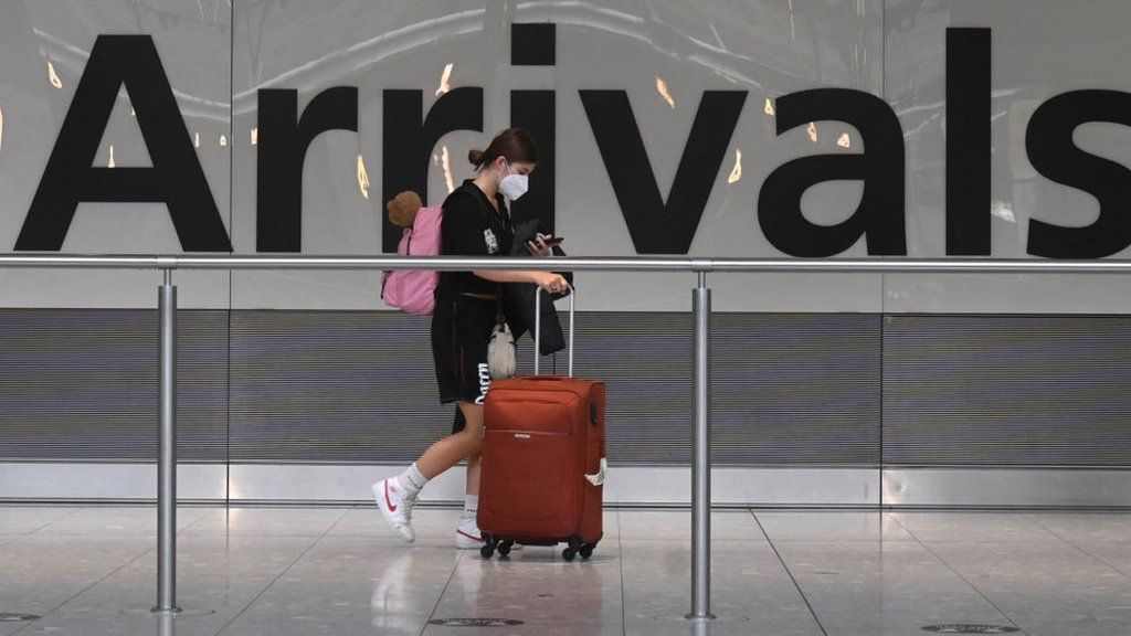 Woman at Arrivals in Heathrow Airport.