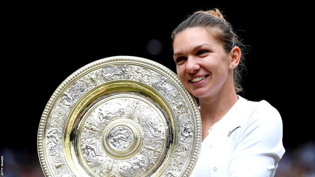 Simona Halep smiles as she lifts the Wimbledon trophy in 2019